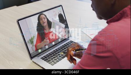 Featuring senior consultant wearing red shirt focusing on laptop in office, with digital city model Stock Photo