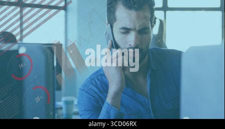 Middle Eastern man talking on smartphone and analyzing laptop charts at office desk, copy space Stock Photo
