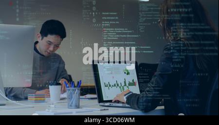 Collaborating colleagues writing notes and typing on laptop in meeting room, with sticky notes Stock Photo