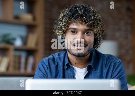 Confident customer service representative with curly hair engaging in a virtual call session. Stock Photo