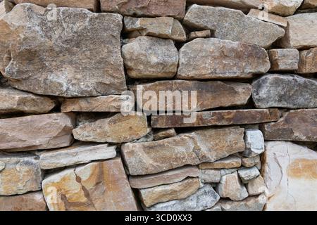 The wall is constructed from various sizes and shapes of natural stones. Stock Photo