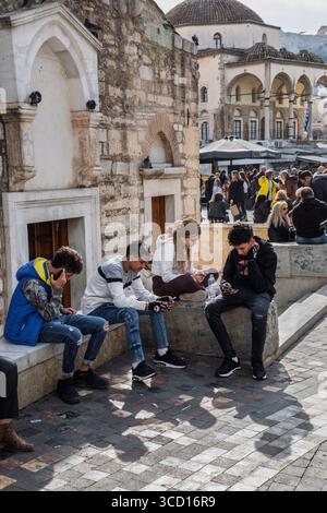 Teenagers on their phones, Monastiraki Square, Athens, Greece Stock Photo