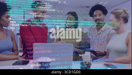 Collaborating tech team gathering around laptop and tablet in office, with holographic code overlay Stock Photo
