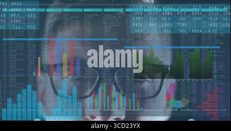 Analyzing adult male examining data overlays via eyeglasses in virtual workspace, with color charts Stock Photo