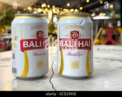 Two Bali Hai Munich Lager beer cans on a marble bar table with blurred bokeh lights in the background creating a festive ambiance, Penang, Malaysia Stock Photo