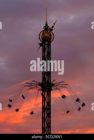 Star flyer swing in Tivoli Gardens at sunset, Copenhagen, Denmark Stock Photo