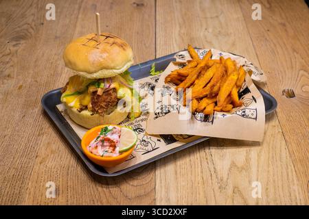 Sheffield, UK 17 March 2020: Buttermilk chicken burger served with loaded fries and coleslaw from Unit Sheffield Stock Photo