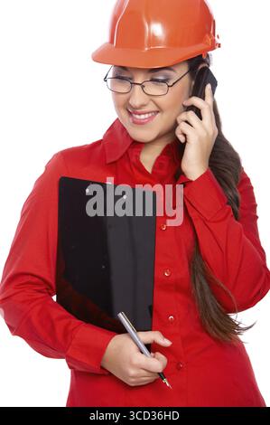 Female architect holding clipboard, using cell phone Stock Photo