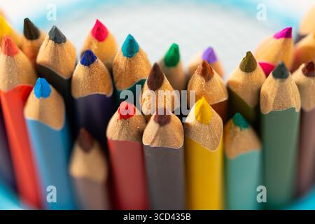 Various colored pencils arranged neatly in a holder signify the excitement of returning to school. Bright hues reflect the creativity and learning that await students this season. Stock Photo