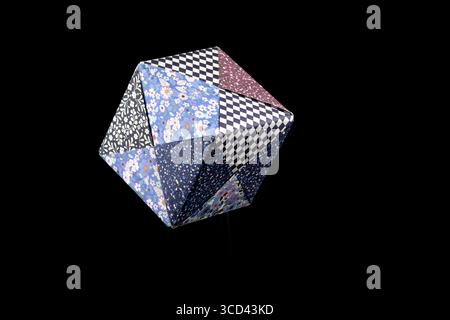 Paper origami cube isolated and suspended on a black background Stock Photo