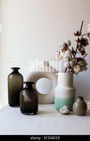 Minimalist home decor with a collection of modern ceramic and glass vases arranged on a neutral surface. Stock Photo