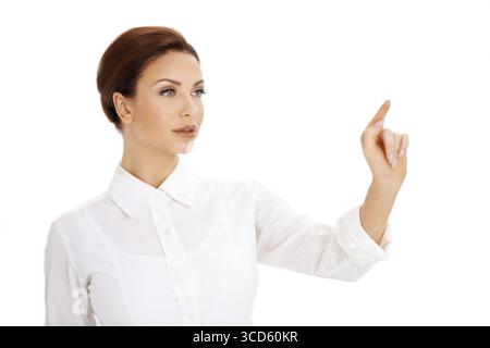 Beautiful woman using a virtual screen pointing with her finger towards blank copyspace with her eyes focused on her fingertip Stock Photo