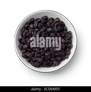 Top view of dried black barberry in ceramic bowl isolated on white Stock Photo