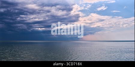 Expansive baltic sea horizon with dramatic cloud formations. Calm waters contrast with striking sky, captured in subtle hues. Atmospheric and tranquil Stock Photo