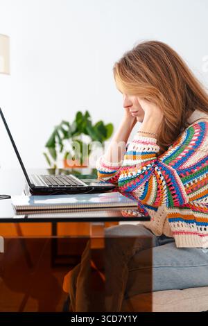Frustrated woman looking at laptop screen while working from home Stock Photo