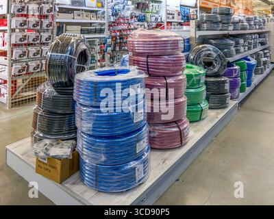 Cuneo, Italy - July 21, 2025: corrugated pipe for electrical cables packaged in rolls of various sizes and colors displayed for sale on a DIY supermar Stock Photo
