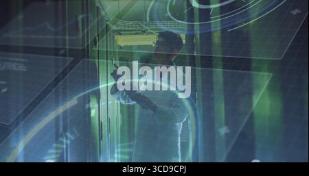 Pointing man wearing white lab coat checking server modules in data center, with HUD graphics Stock Photo