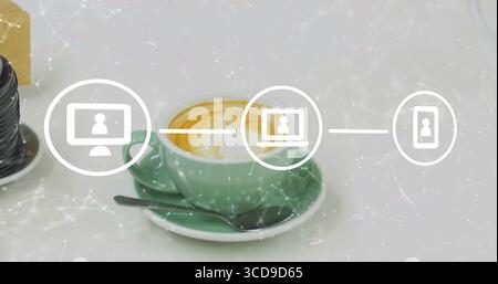 Displaying green coffee cup resting on saucer on white desk, with metal spoon, lens, network icons Stock Photo