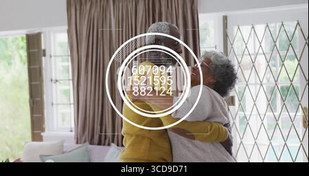 Hugging mother and son sharing warm embrace on sofa in living room, with pastel cushions Stock Photo