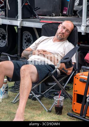 Adult male falls asleep in his chair at a music festival in Montrose, Colorado. USA Stock Photo