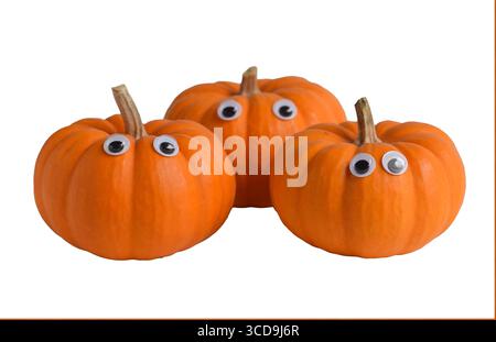 Three mini orange pumpkins with googly eyes on white Stock Photo