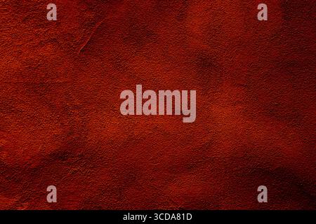 Deep red textured surface resembling natural earthy tones, ideal for use as a grunge background or artistic canvas. Stock Photo