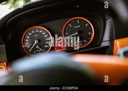 Illuminated car dashboard displaying speed, rpm, temperature, and mileage, highlighting automotive technology and driver information Stock Photo