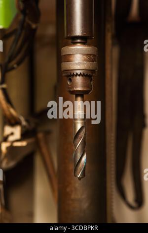 A drill inserted into a chuck on a drilling machine. Stock Photo