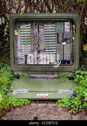 Vandalised telecoms box with exposed telephone wires and damaged connections. UK Stock Photo