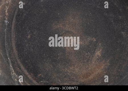 Close-up of a ceramic flat plate with a dark brown finish and dust and dirt stains, used for a background or texture Stock Photo
