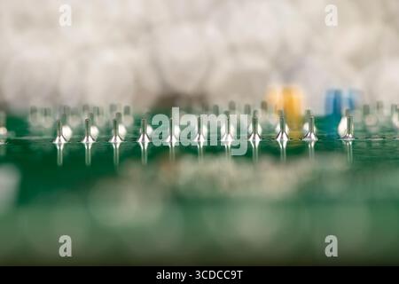 green circuit board with contacts, a simple green printed circuit board with an electronic circuit with soldered elements Stock Photo
