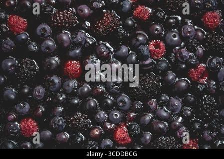 Berries overhead closeup baked on tart. Colorful assorted mix of blueberry, raspberry, blackberry, red currant. Top view, flat lay Stock Photo