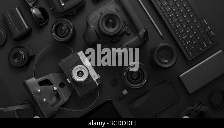 Photographer workspace concept. Various digital and analog gadgets placed on black background. Computer keyboard, digital camera, analog camera, phone Stock Photo