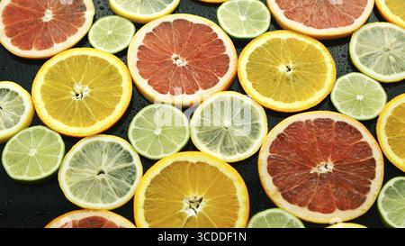 From above assortment of sliced lime, lemon, grapefruit and orange on dark background Stock Photo