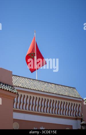 Moroccan flag flying against a clear blue sky above the souk market in the medina in Marrakesh, Morocco Stock Photo