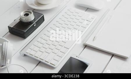 From above view of different office gadgets with photo camera laid near on white background Stock Photo