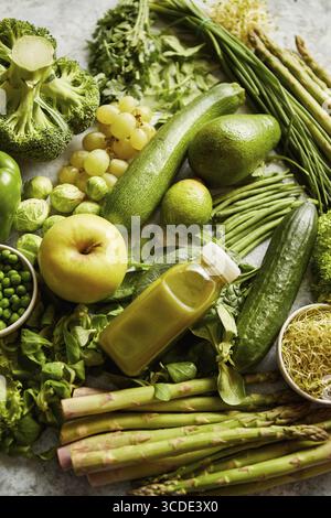 Green antioxidant organic vegetables, fruits and herbs placed on gray stone table. Top view with copy space Stock Photo