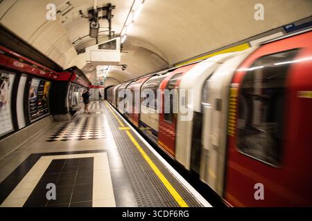 Motion-blurred Central Line train arriving at Holborn station on the London Underground, capturing speed, movement, and urban energy. Stock Photo