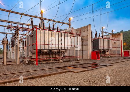 A close-up of a power transformer within an electrical substation in Brazil, showcasing the complex network of wires and insulators. Stock Photo