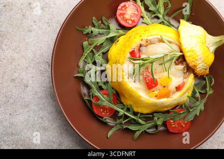 Tasty stuffed pattypan squash with tomatoes and arugula on grey table, top view Stock Photo