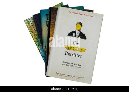Selection of hardback books with The Secret Barrister book Stories of the Law and How It's Broken on top isolated on white background Stock Photo
