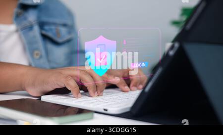 Online security, data protection, and safe access in a professional setting.Close-up of hands typing on keyboard with digital shield and padlock overl Stock Photo