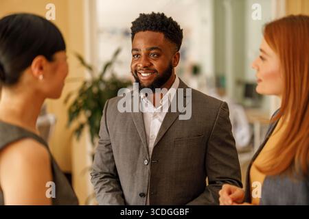 Confident male lawyer brainstorming ideas and discussing strategies with female colleagues in office Stock Photo