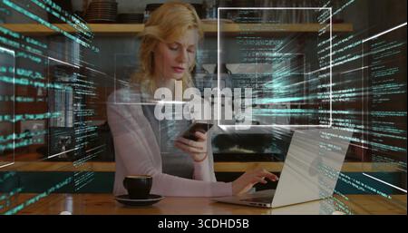 Typing female programmer using smartphone and laptop at cafe, with coffee cup and code overlays Stock Photo