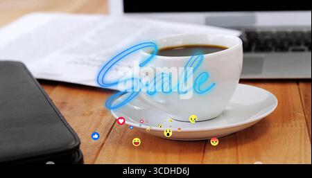 Displaying coffee cup on saucer on office desk beside laptop, showing neon Sale with emojis Stock Photo