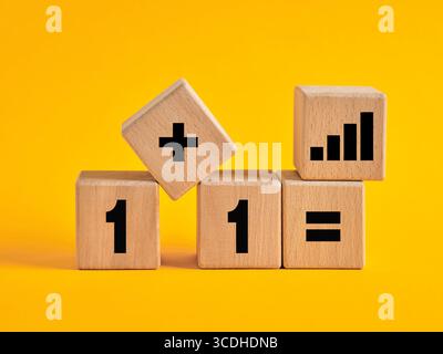 Wooden cubes showing the concept of synergy and exponential growth through teamwork and partnership leading to success Stock Photo