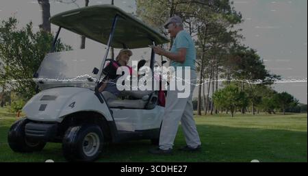 Reviewing scorecard by golfers wearing polo shirts at white cart on sunlit fairway, with clubs Stock Photo