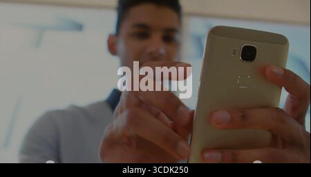 Holding gold smartphone with both hands, adult man interacting with touchscreen in showroom windows Stock Photo