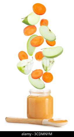 Baby food. Apple and carrot slices falling into jar of puree on white background Stock Photo