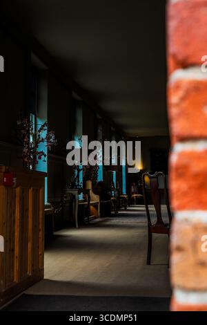 Cozy Dimly Lit Room with Vintage Chairs and Blue-Tinted Windows Stock Photo
